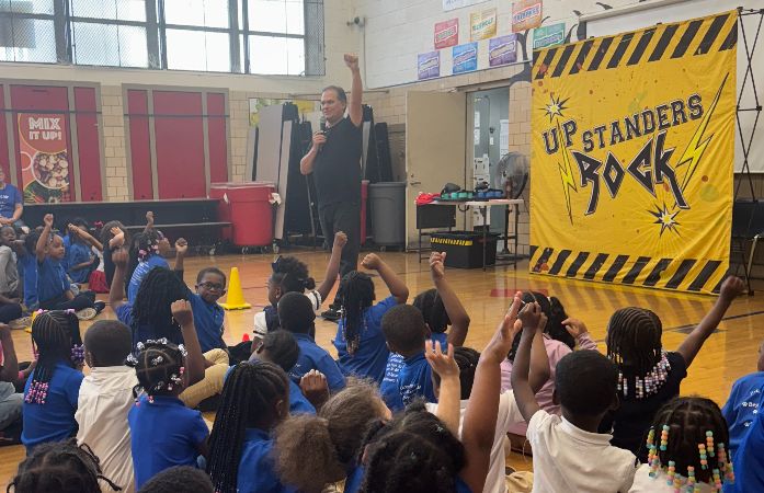  Up Stranders Rock presenter with students on the gym floor.